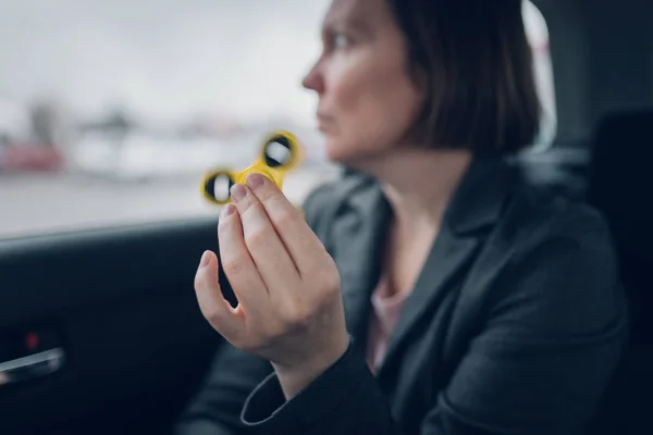 Geschäftsfrau spielt mit Fidget Spinner im Auto — Stockfoto