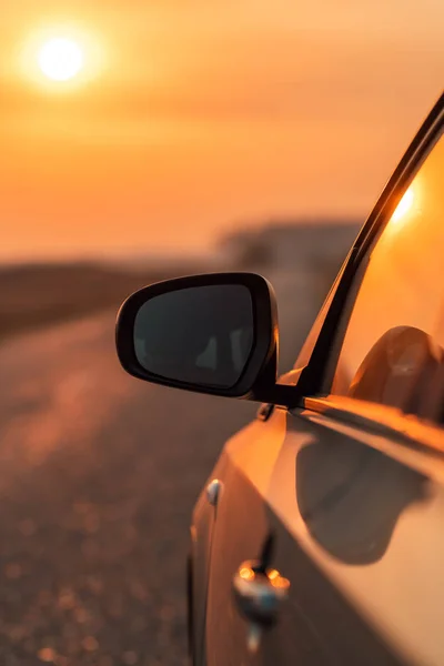 Espejo de vista lateral del coche en la carretera en otoño puesta de sol —  Fotos de Stock