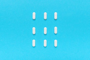 Beyaz oval tabletlerle kaplanmış, düz görünüm.