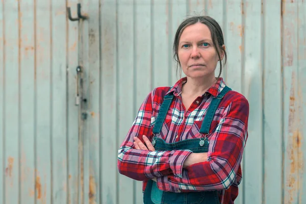 Portræt af smukke kvindelige landmand foran gård skur - Stock-foto