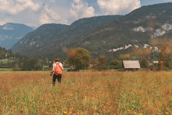 Senderista femenina es trekking en el paisaje rural alpino en autu — Foto de Stock