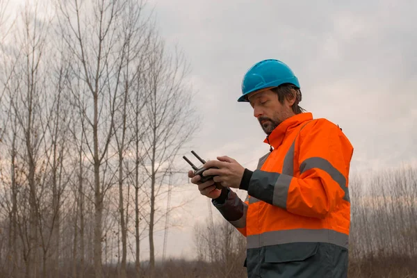 Técnico florestal pilotando um drone com controle remoto — Fotografia de Stock