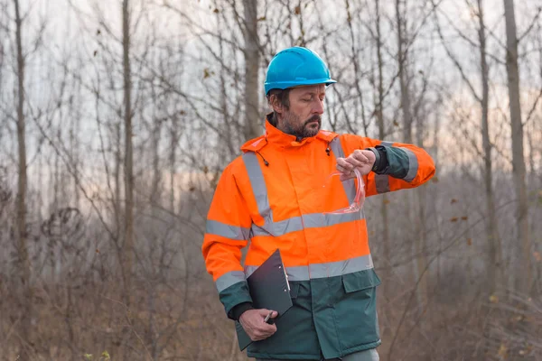 彼のスマートウォッチをチェックする林業技術者 — ストック写真