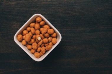 Masada servis edilen barbekü sosuyla kaplı tuzlu fıstık çerezi.