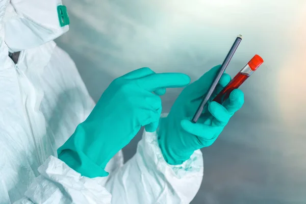 Epidemiologista com smartphone e amostra de sangue em tubo de teste — Fotografia de Stock