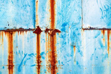 Grunge paslı metal yüzeyi maviyle boyanmış.