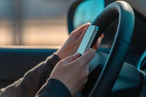 Empresaria conduciendo coche y mensajes de texto en el teléfono móvil — Foto de Stock