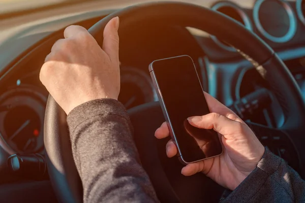 Empresaria conduciendo coche y mensajes de texto en el teléfono móvil — Foto de Stock