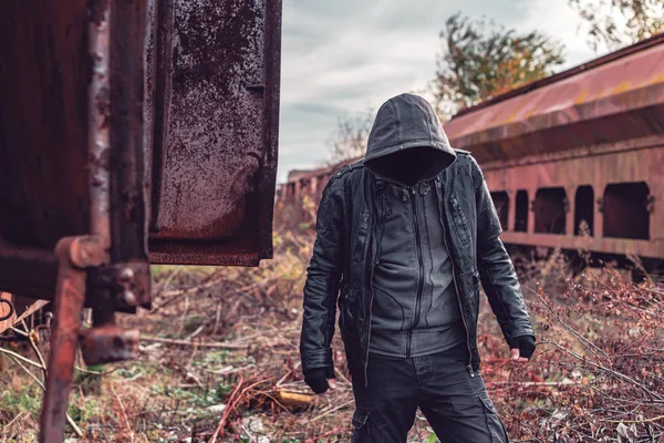 Homem sem-teto encapuzado sem rosto entre o velho trem de carga obsoleto wa — Fotografia de Stock