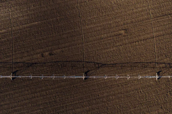 ドローンのポップ 農業や農業機器から耕されたフィールド上のセンターピボット灌漑システムの空中ビュー — ストック写真