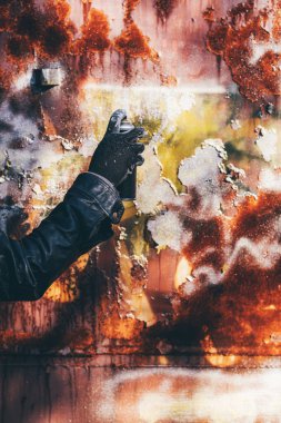 Homeless man spray painting old train wagon with aerosol can. Unrecognizable male person hand close up in conceptual image with selective focus. clipart