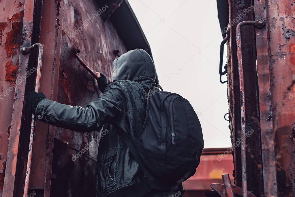 Homeless immigrant climbing on freight train, conceptual image with selective focus