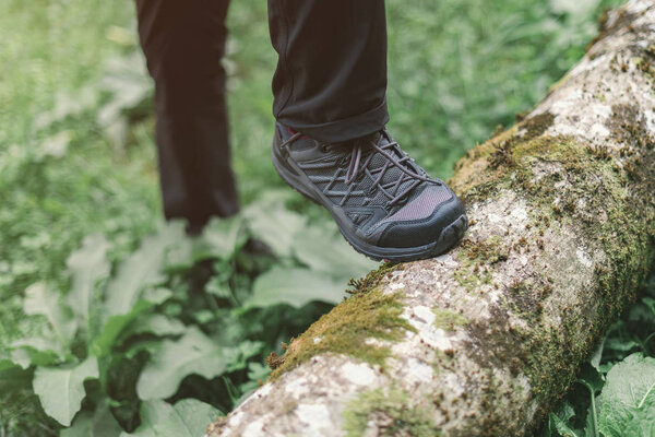 Hiking shoe trekking in woods, selective focus of female hiker feet walking in forest