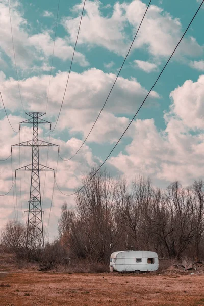 Verlaten Kampwagen Aanhanger Het Veld Met Elektriciteitsmasten — Stockfoto