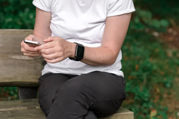 Female Hiker Using Smartphone Smart Watch While Resting Bench Park — Stock Photo, Image