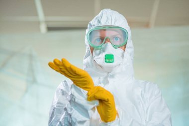 Virüs karantinasında kadın epidemiyolojistin portresi, koruyucu giysiler içinde tıbbi profesyonelin yakın plan fotoğrafı.
