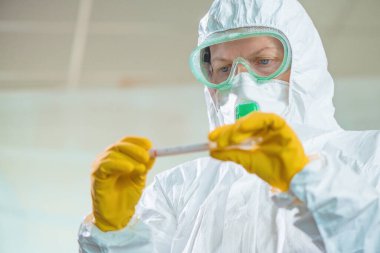 Virüs karantinasında test tüpü kullanan kadın epidemiyoloji uzmanı.