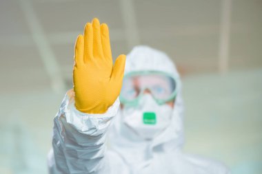 Kadın epidemiyoloji uzmanı hastane karantinasında dur işareti gösteriyor.