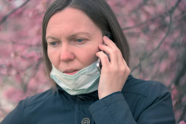 Frau Telefoniert Mit Atemmaske Blühenden Kirschbaumpark — Stockfoto