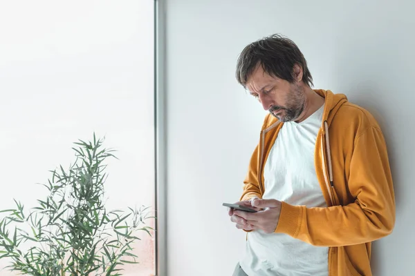 Man Yellow Zip Hoodie Using Mobile Phone Morning Standing Window — Stock Photo, Image