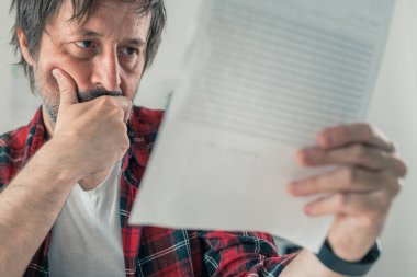 İşletme sözleşmesini ve hizmet belgelerinin şartlarını okuyan serbest çalışan endişeli, seçici odaklı