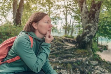 Dişi yürüyüşçü dinleniyor ve ormanda tefekkür ediyor. Ormanda yürüyüş yapmaya ara veriyor.