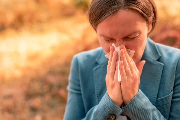 Businesswoman Nos Foukání Papírové Tkáně Podzimním Parku Během Pracovní Přestávky — Stock fotografie