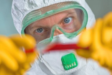 Epidemiyoloji uzmanı virüs karantinasında tıbbi örnek test tüpünü inceliyor, viral enfeksiyon salgını sırasında hastanın kanını test ediyor.