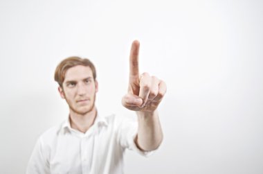 Beyaz gömlek parmağıyla işaret içinde genç yetişkin erkek