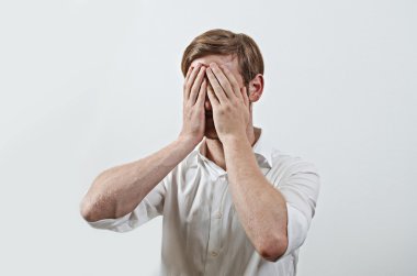 Adam elleriyle yüzünü kapatıyor.