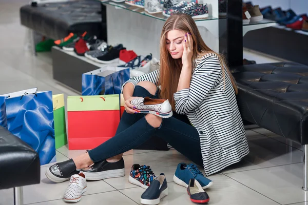 Giovane donna in negozio di scarpe — Foto Stock