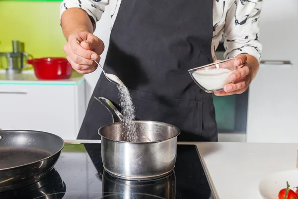 La main de l'homme tamiser le sucre dans la casserole — Photo