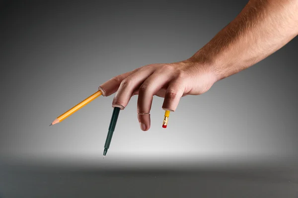 Hand with pen and pencil instead of fingers — Stock Photo, Image