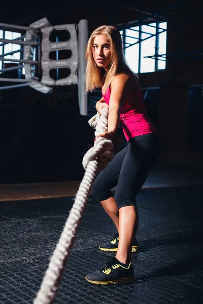 Chica tirando de la cuerda en gimnasio — Foto de Stock