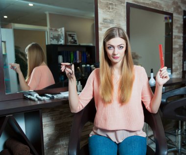 makas ve saç fırçası ile genç kadın 