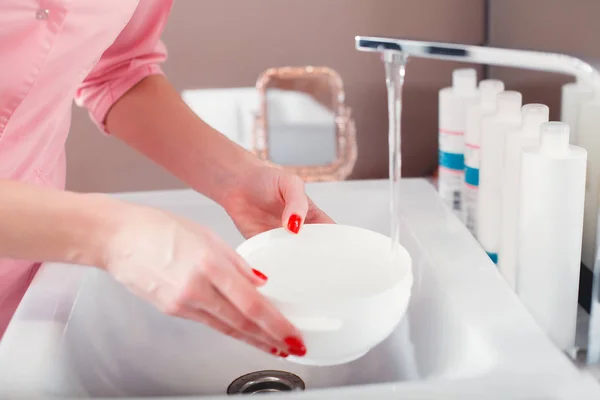 Doctor holding white cosmetic bowl — Stock Photo, Image