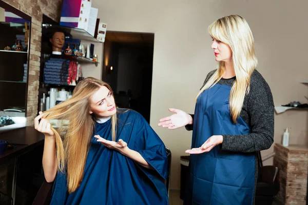 Красивая женщина показывает волосы парикмахеру — стоковое фото