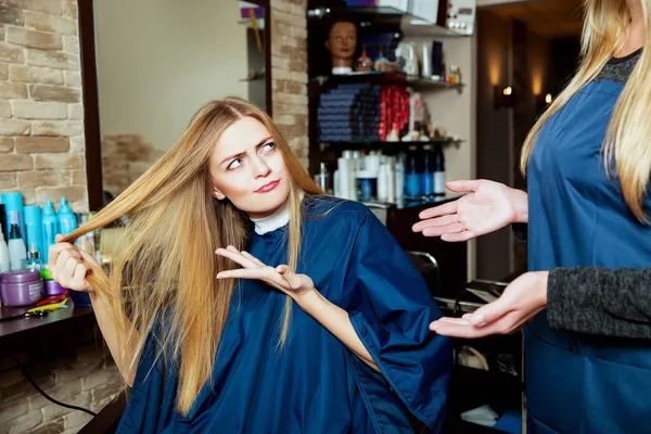 Beautiful woman showing hair to hairdresser — Stock Photo, Image