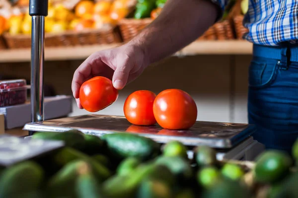 Продавец кладет помидоры на весы — стоковое фото