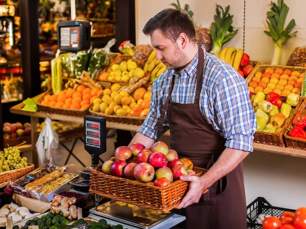 Säljaren att sätta lådan med äpplen på vikter — Stockfoto