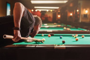 Bilardo topu vurmak çalışan adam 