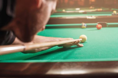 Bilardo topu vurmak çalışan adam 