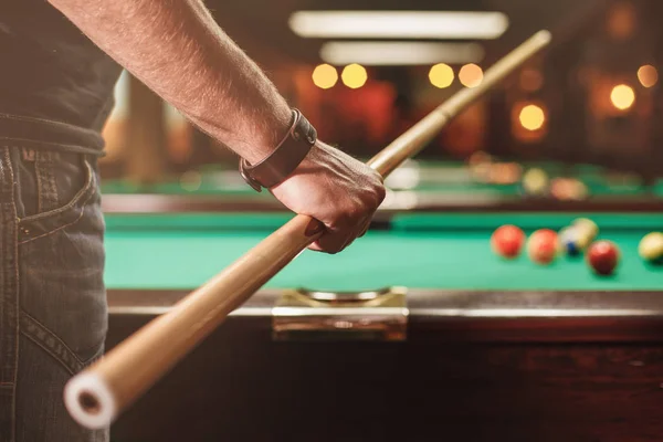 Man met cue in de buurt van de biljarttafel — Stockfoto