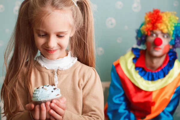 Улыбающаяся маленькая девочка держит кекс — стоковое фото