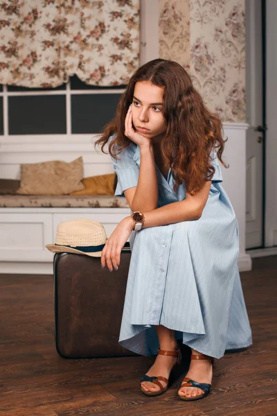 Jeune femme assise sur une valise — Photo