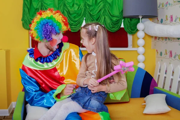 Ragazza che gioca con clown allegro — Foto Stock