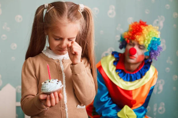 Chica sosteniendo cupcake con vela y llorando — Foto de Stock