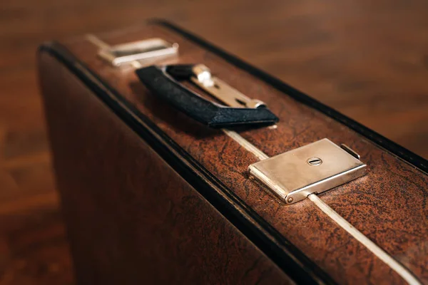 Closed retro suitcase on wooden floor — Stock Photo, Image