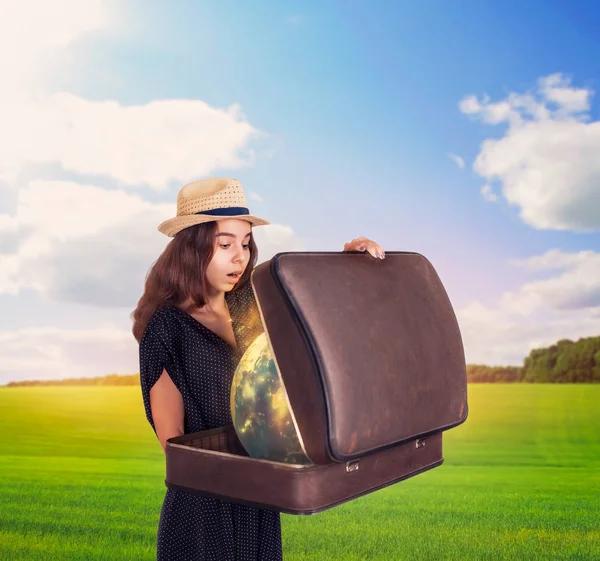 Frau hält Koffer mit magischer Weltkugel — Stockfoto