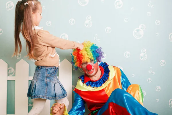 Mała dziewczynka ciągnąc peruka clown — Zdjęcie stockowe